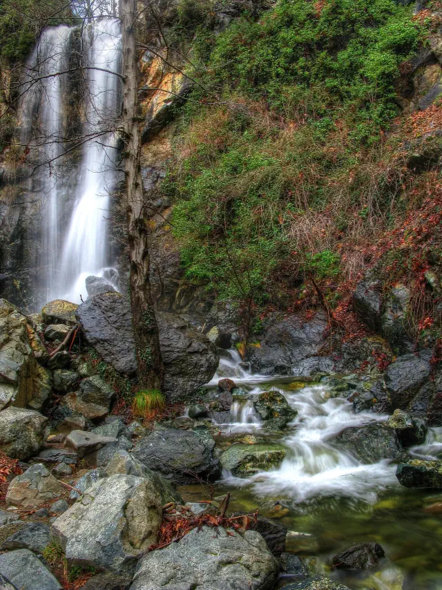 De Caledonia-waterval bij Platres valt over een rotswand in de keienbedding van de Kryos