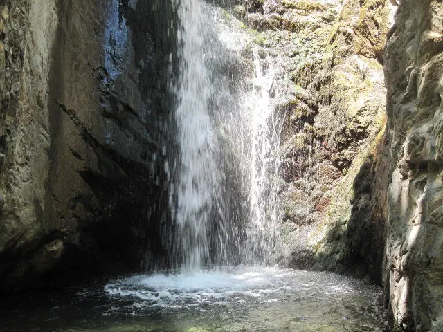 De Millomeris-waterval bij Platres stort tussen twee rotswanden in een ondiepe kom